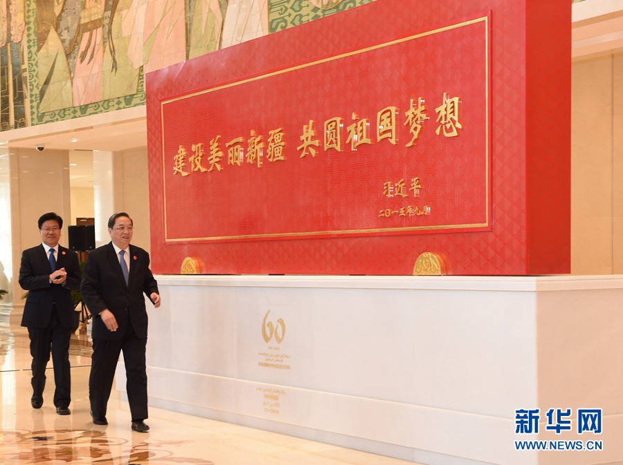 這是俞正聲和中共中央政治局委員、新疆維吾爾自治區(qū)黨委書記張春賢一同為習近平總書記題詞賀匾揭幕。新華社記者 高潔 攝 