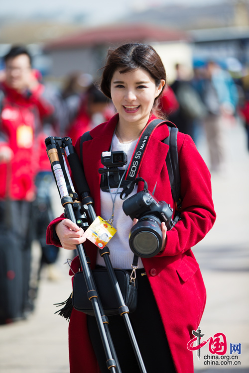 2016年兩會(huì)，人民大會(huì)大堂前，一位笑容燦爛的紅衣女記者正步入大會(huì)堂。中國網(wǎng) 鄭亮 攝