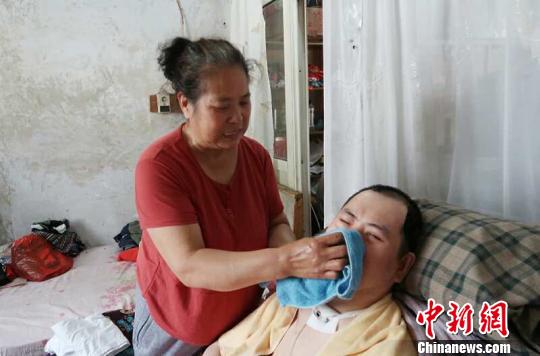 每次喂完食物后，梁青蘭都要仔細(xì)地幫兒子清理干凈?！∩忻鱾b 攝