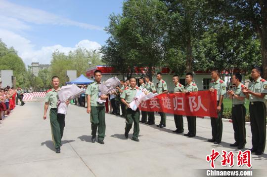 部隊(duì)官兵們迎接出院歸來的李運(yùn)飛(中)和其他消防戰(zhàn)士。　汪渝 攝