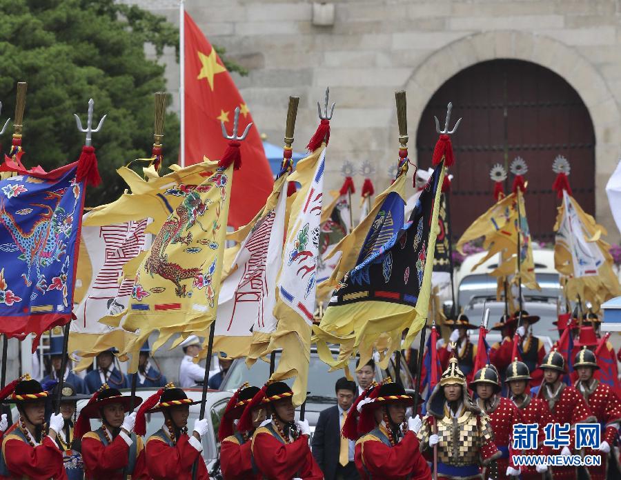 7月3日，韓國(guó)總統(tǒng)樸槿惠在青瓦臺(tái)總統(tǒng)府舉行隆重儀式，歡迎中國(guó)國(guó)家主席習(xí)近平對(duì)韓國(guó)進(jìn)行國(guó)事訪問。這是習(xí)近平的車隊(duì)在身著民族服裝的韓國(guó)禮儀隊(duì)伍引導(dǎo)下駛?cè)肭嗤吲_(tái)。新華社記者丁林?jǐn)z  