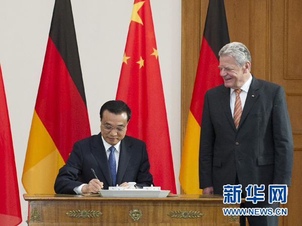10月10日，國務(wù)院總理李克強在柏林會見德國總統(tǒng)高克。這是李克強總理在高克總統(tǒng)的陪同下在貴賓簿上簽字。 新華社記者 王曄 攝 